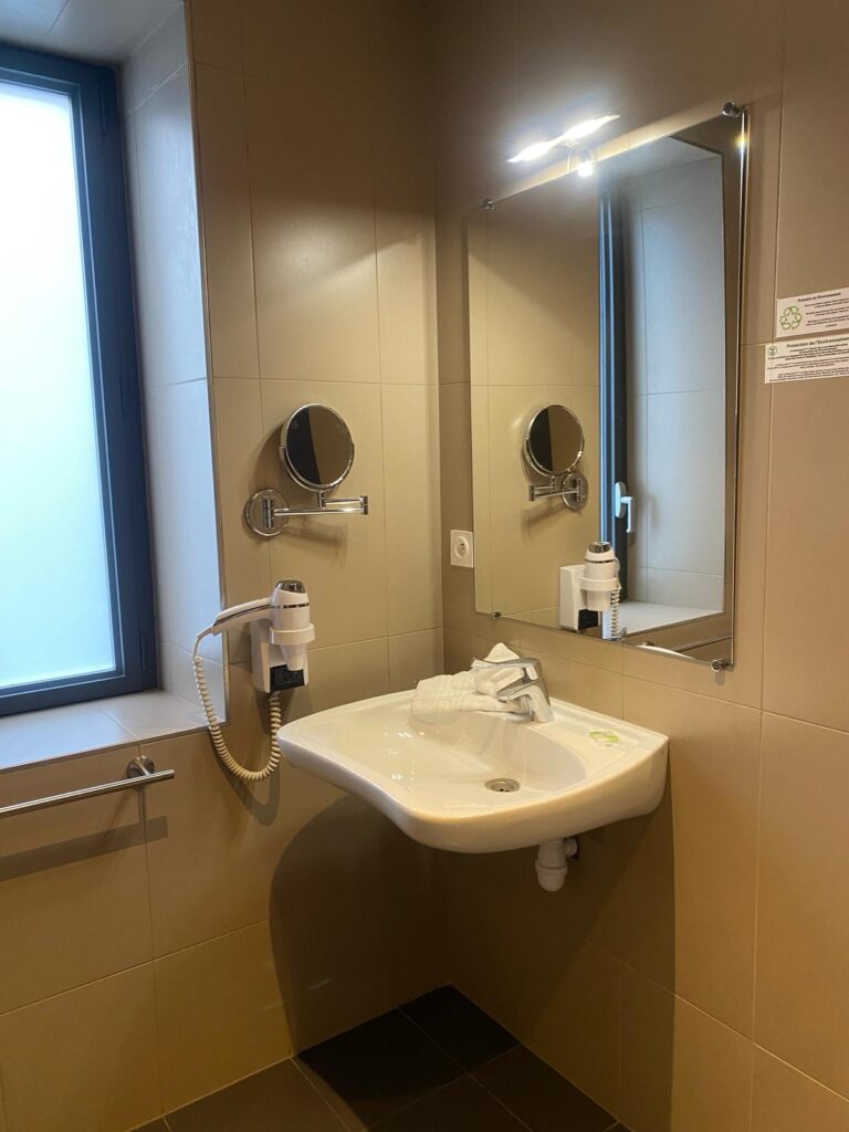 Salle de bains d’une chambre PMR : lavabo et miroir