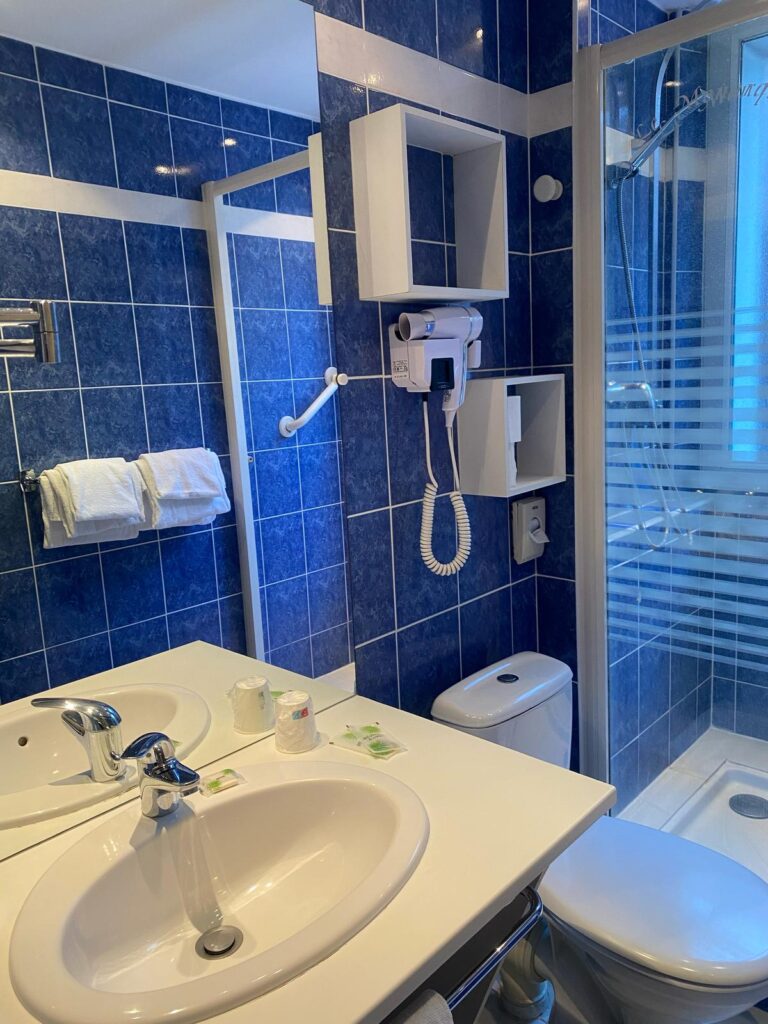 Salle de bains carrelée de bleu avec lavabo