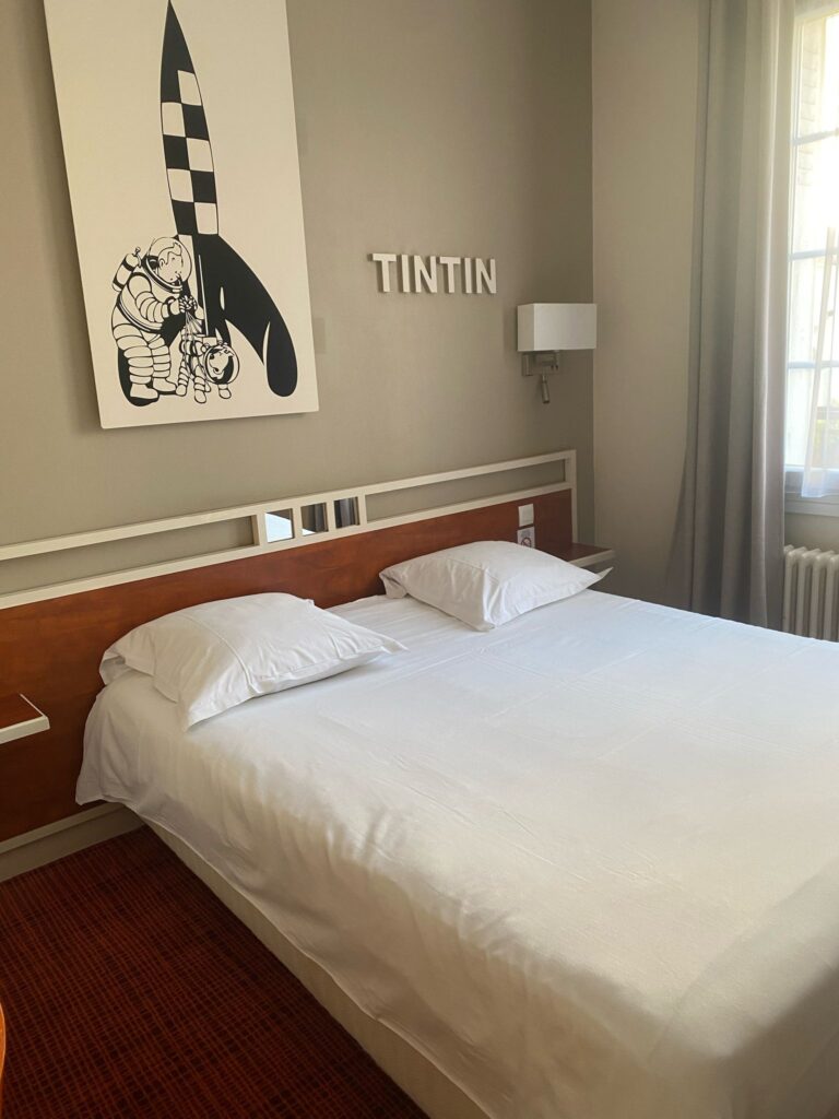 Chambre avec lit et affiche de BD au mur
